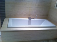 Salle de bain en Moca Creme.
Revêtement mural, tablette et tablier de baigoire découpés sur mesure